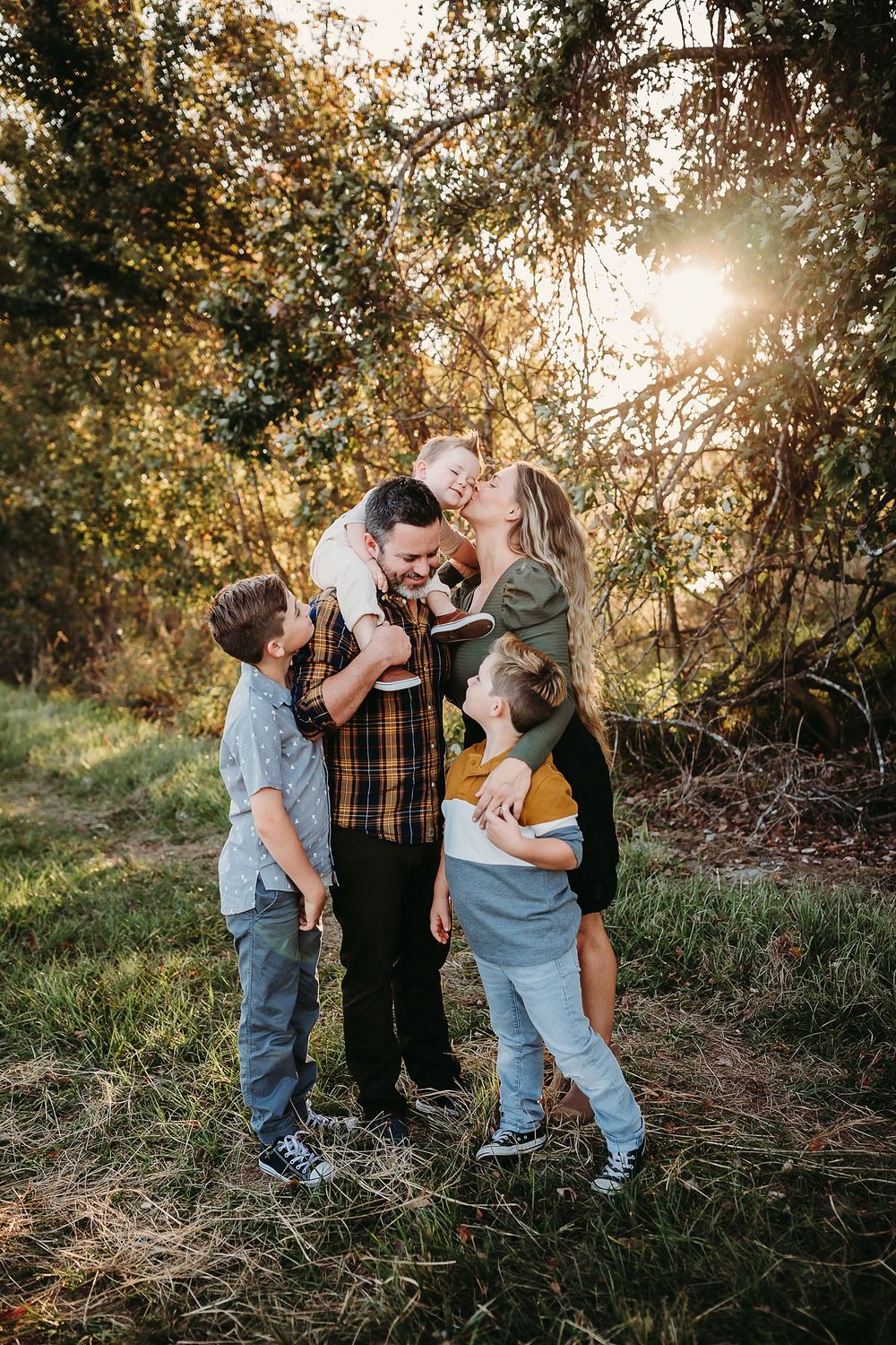 A series of candid outdoor family portraits taken in warm sunset lighting with autumn trees in the background.