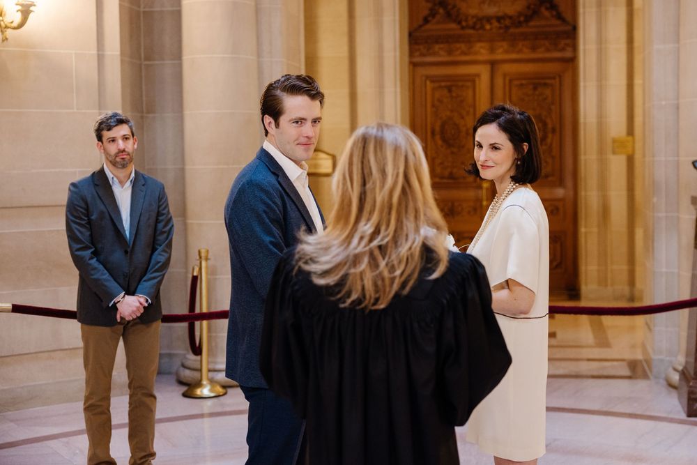 A couple sharing a sweet moment during their wedding ceremony at San Francisco City Hall's grand interior.