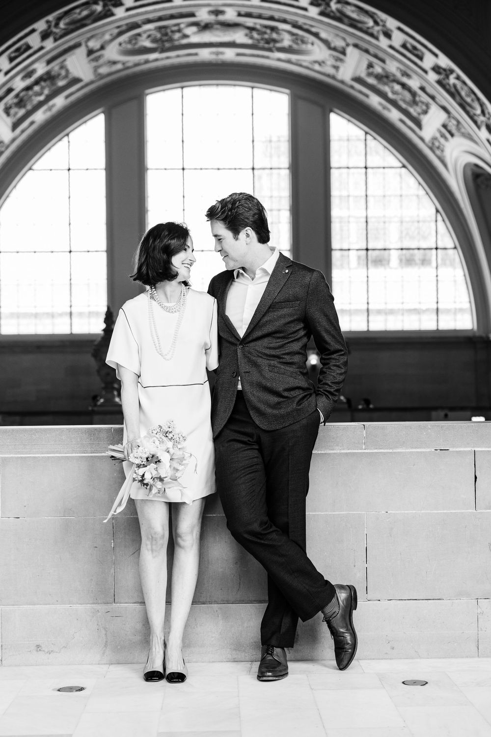 Black and white photo series showing couple in vintage-style poses against arched windows.