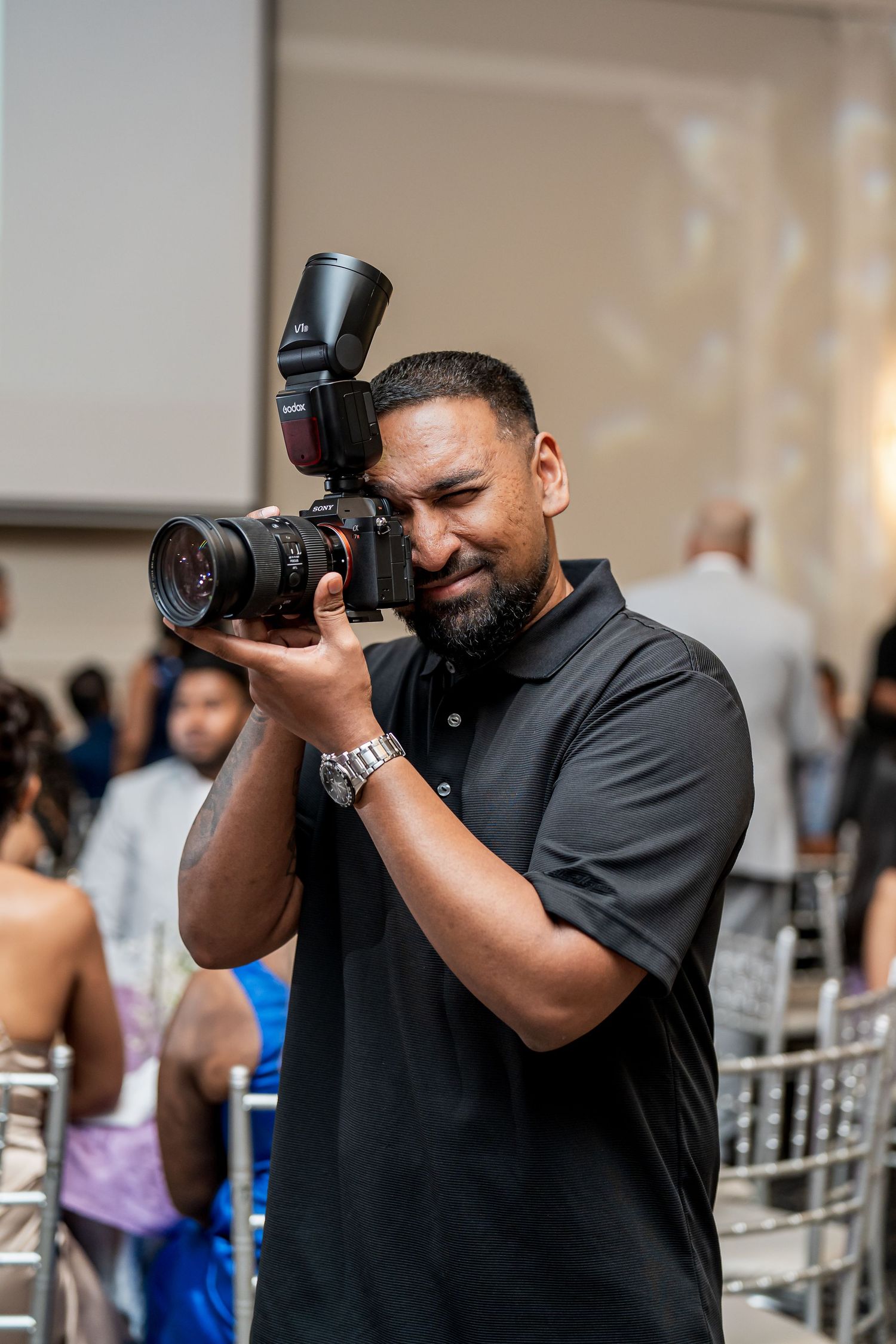 Professional photographer capturing moments at an event with camera equipment.