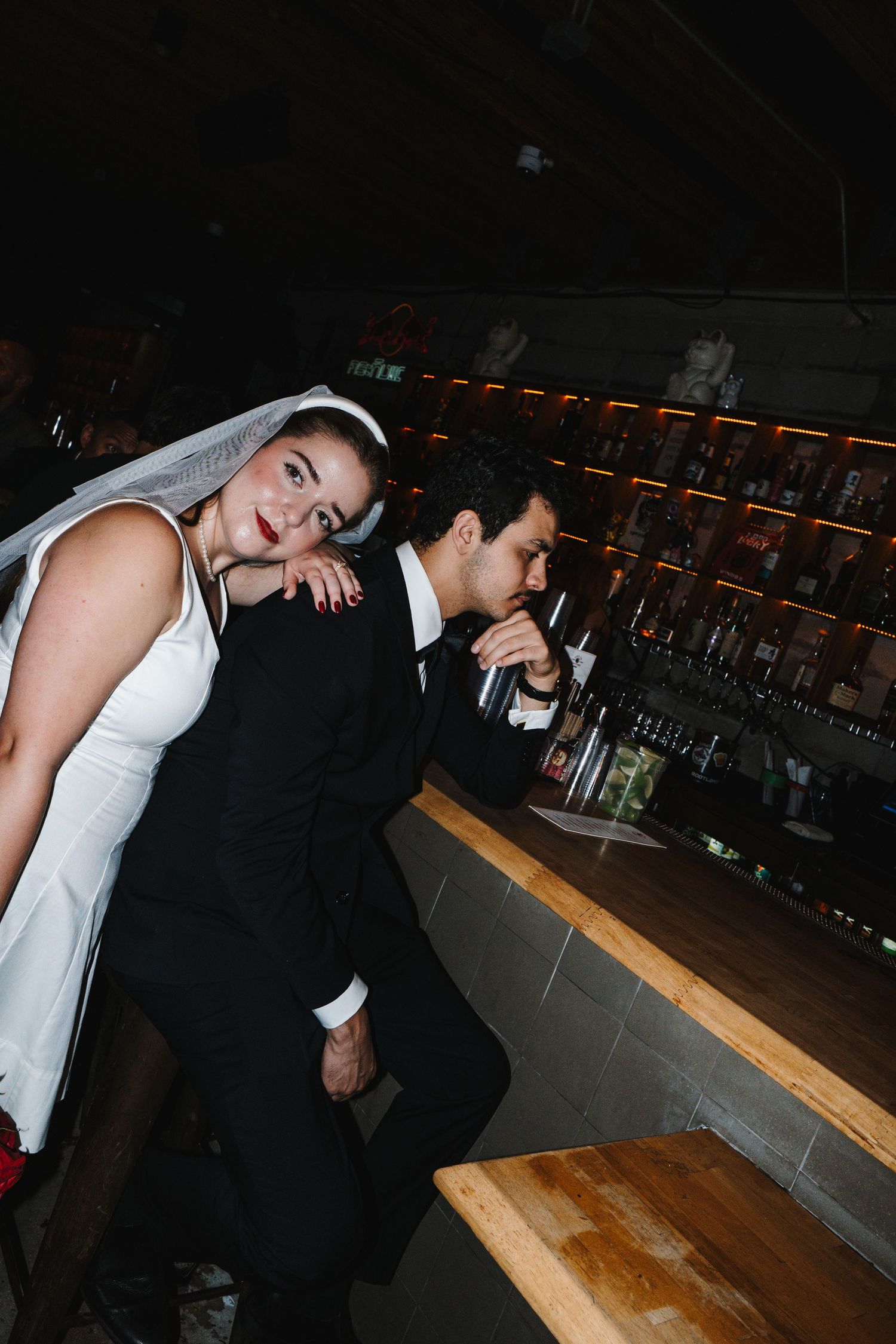 Four sequential photos show someone in white leaning on a wooden bar counter in a dimly lit establishment.