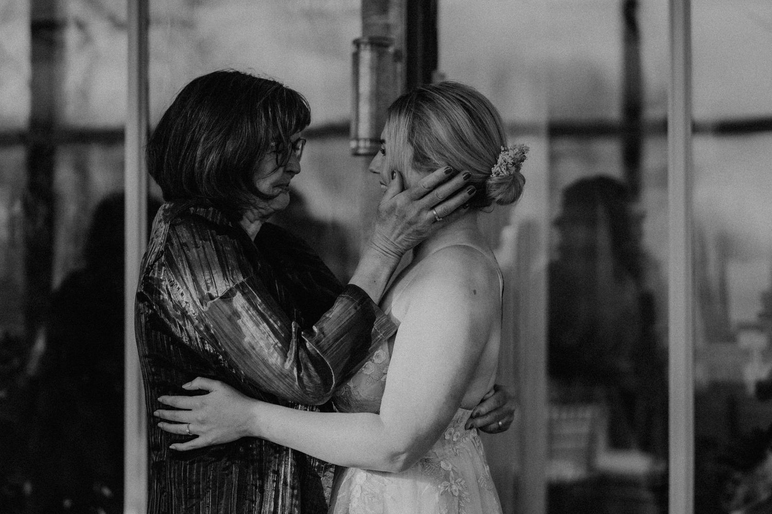 An intimate black and white portrait of two people sharing a tender moment.
