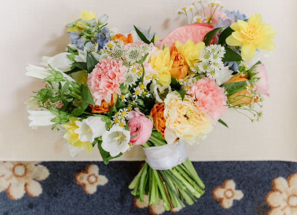 Colorful spring wedding bouquets with pink, yellow and white flowers arranged in a decorative display.