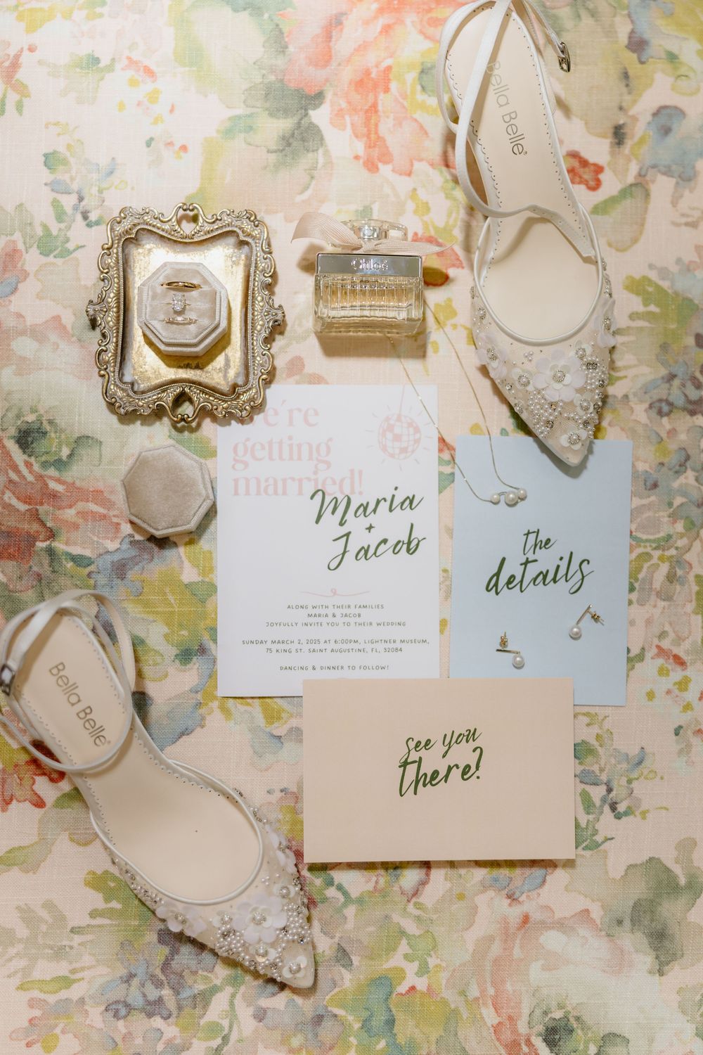 Elegant wedding invitations and decorative frames displayed on a floral patterned background.