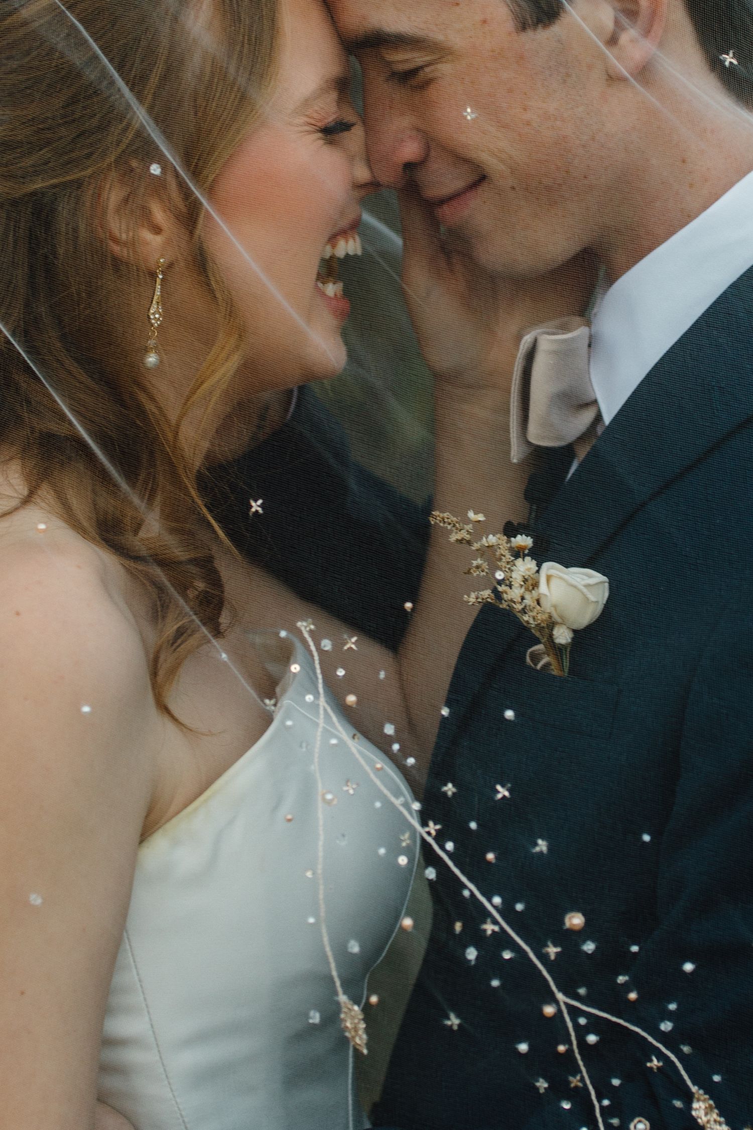 An intimate wedding portrait with decorative sparkle overlays against a soft neutral background.