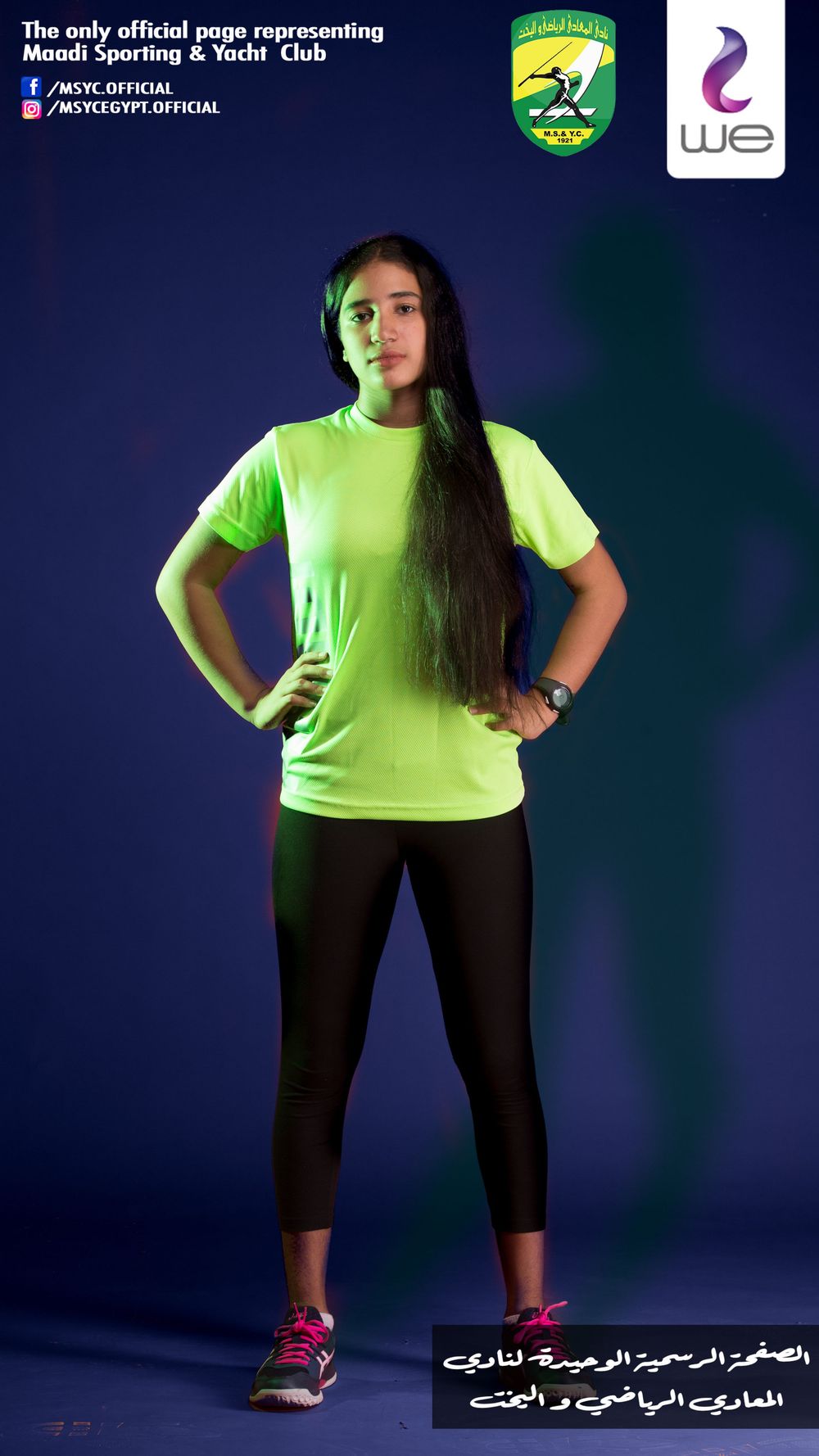 Female squash player in neon yellow shirt and black pants posing against blue backdrop.
