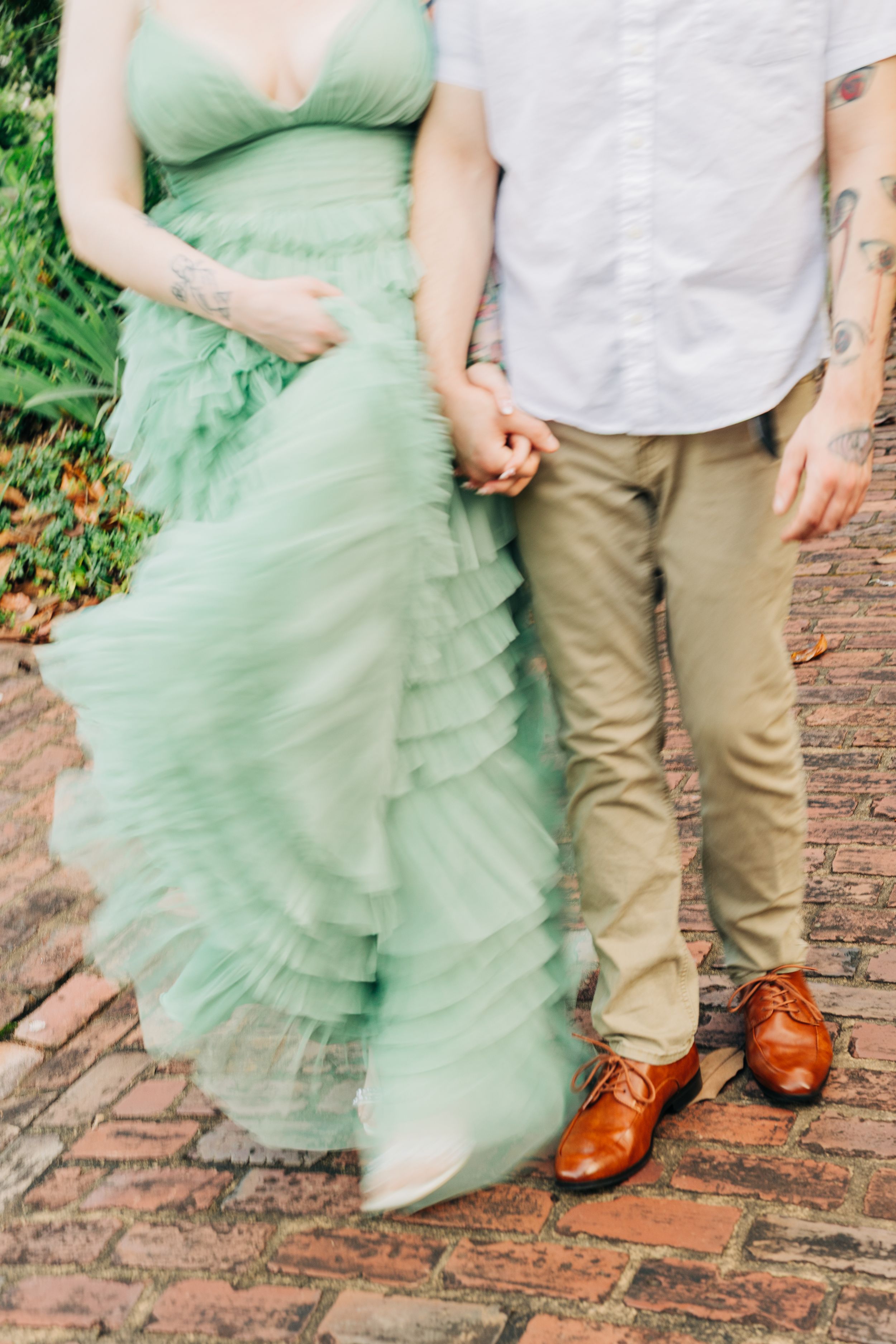 Close-up series showing flowing mint green tulle dress details and brown leather shoes against brick pavement.
