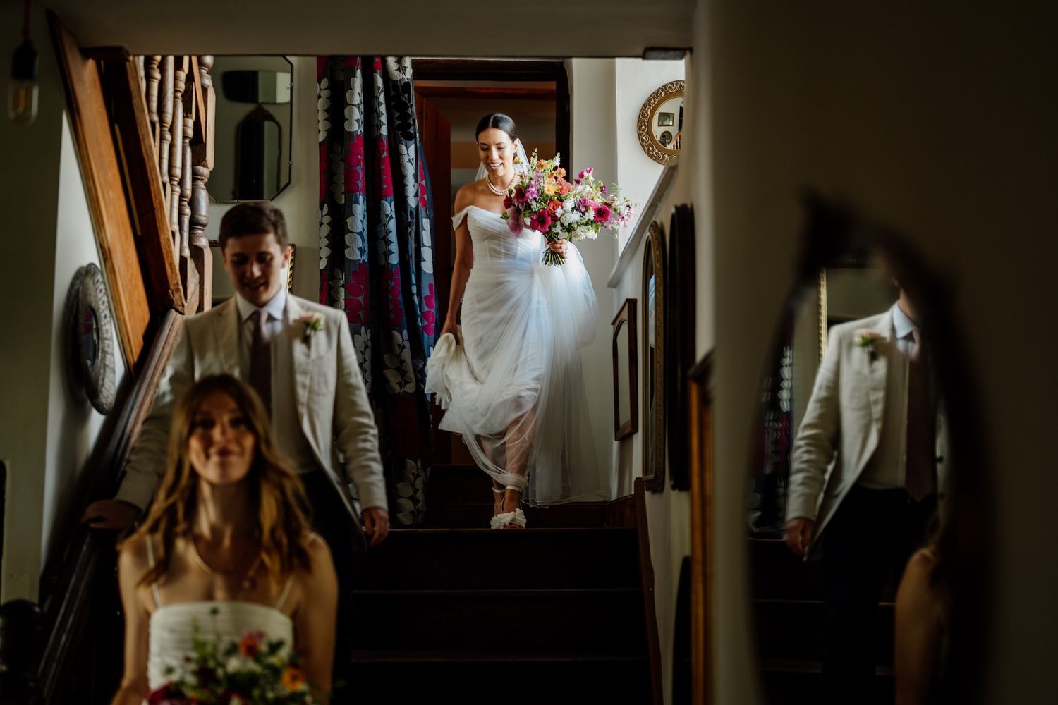 A sequence of wedding preparation moments captured in dark moody lighting showing details of a dress and getting ready.