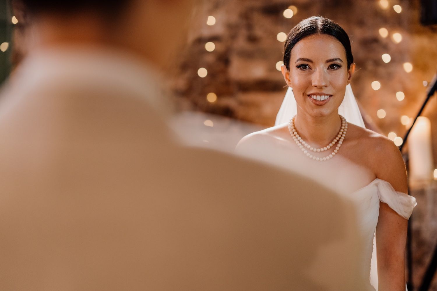 Warm ambient lighting creates a romantic atmosphere at an indoor wedding celebration.