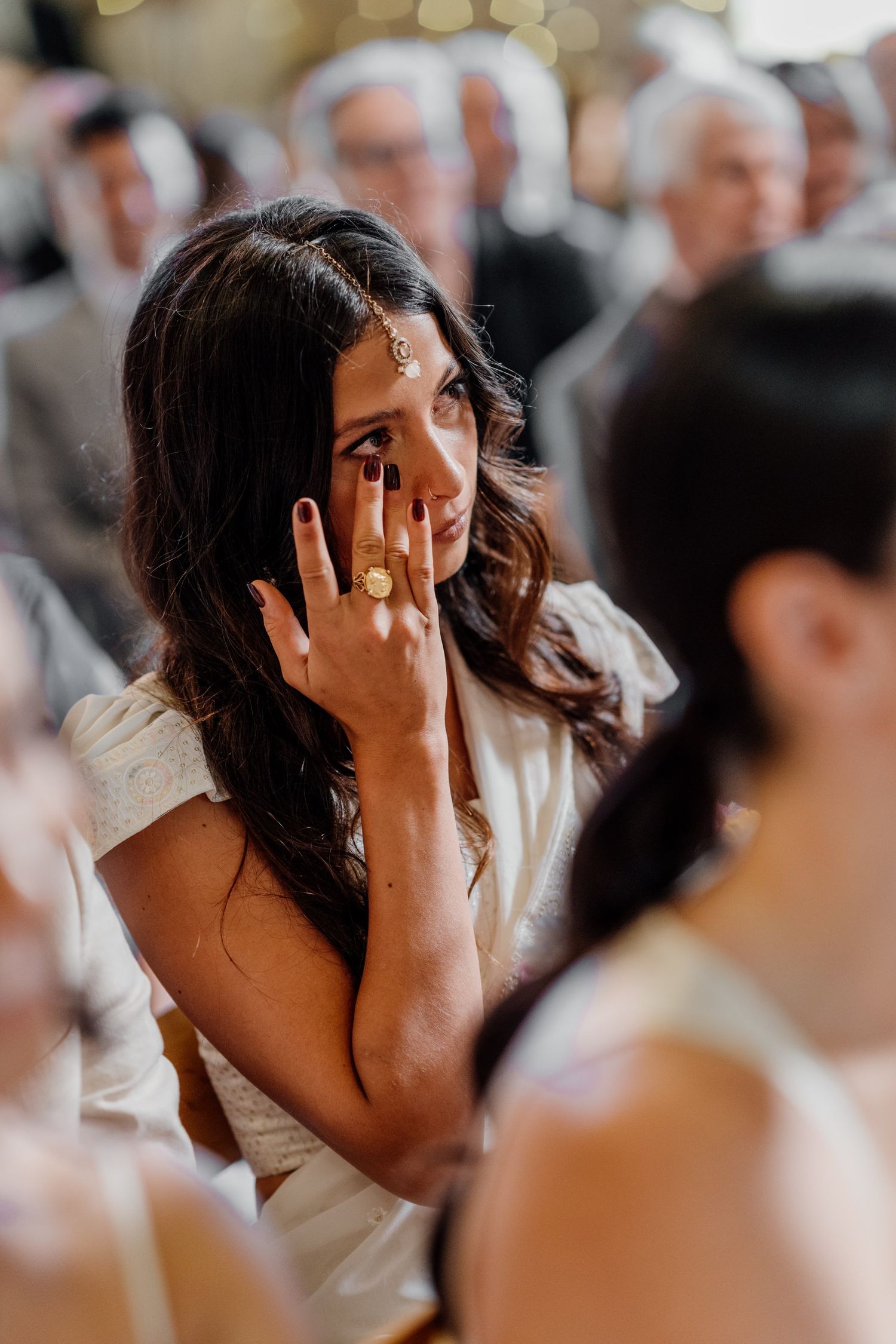 Emotional moment captured during wedding reception with soft bokeh lighting.