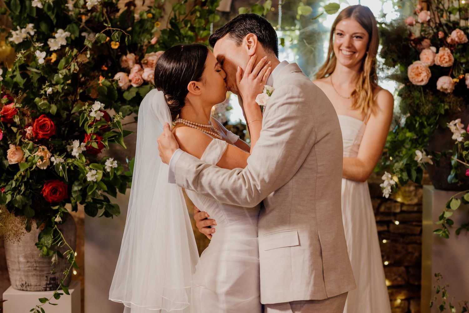 Beautiful floral decor with pink and red blooms frames a wedding celebration moment.