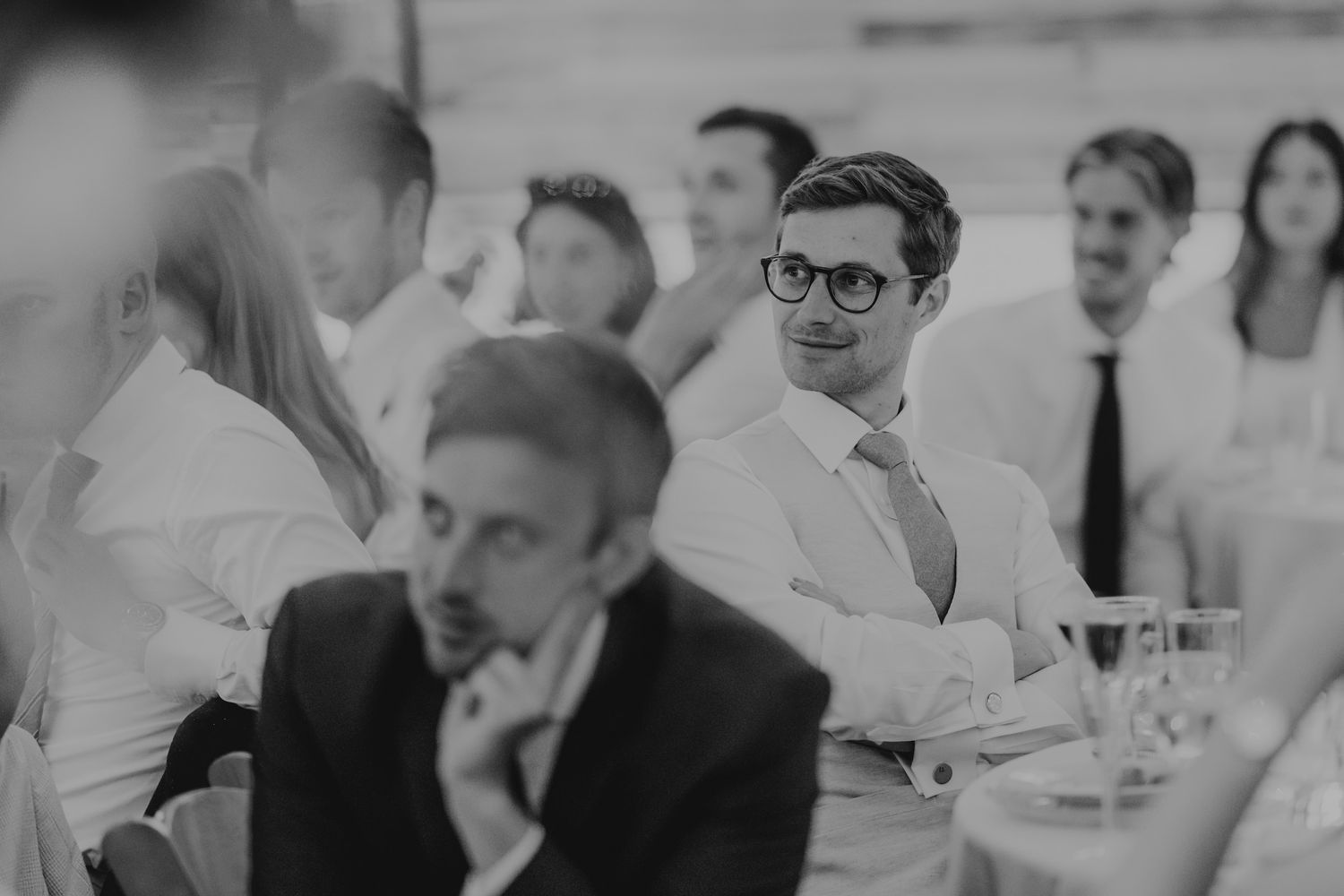 Wedding guests enjoy conversation at an elegant reception dinner in black and white.