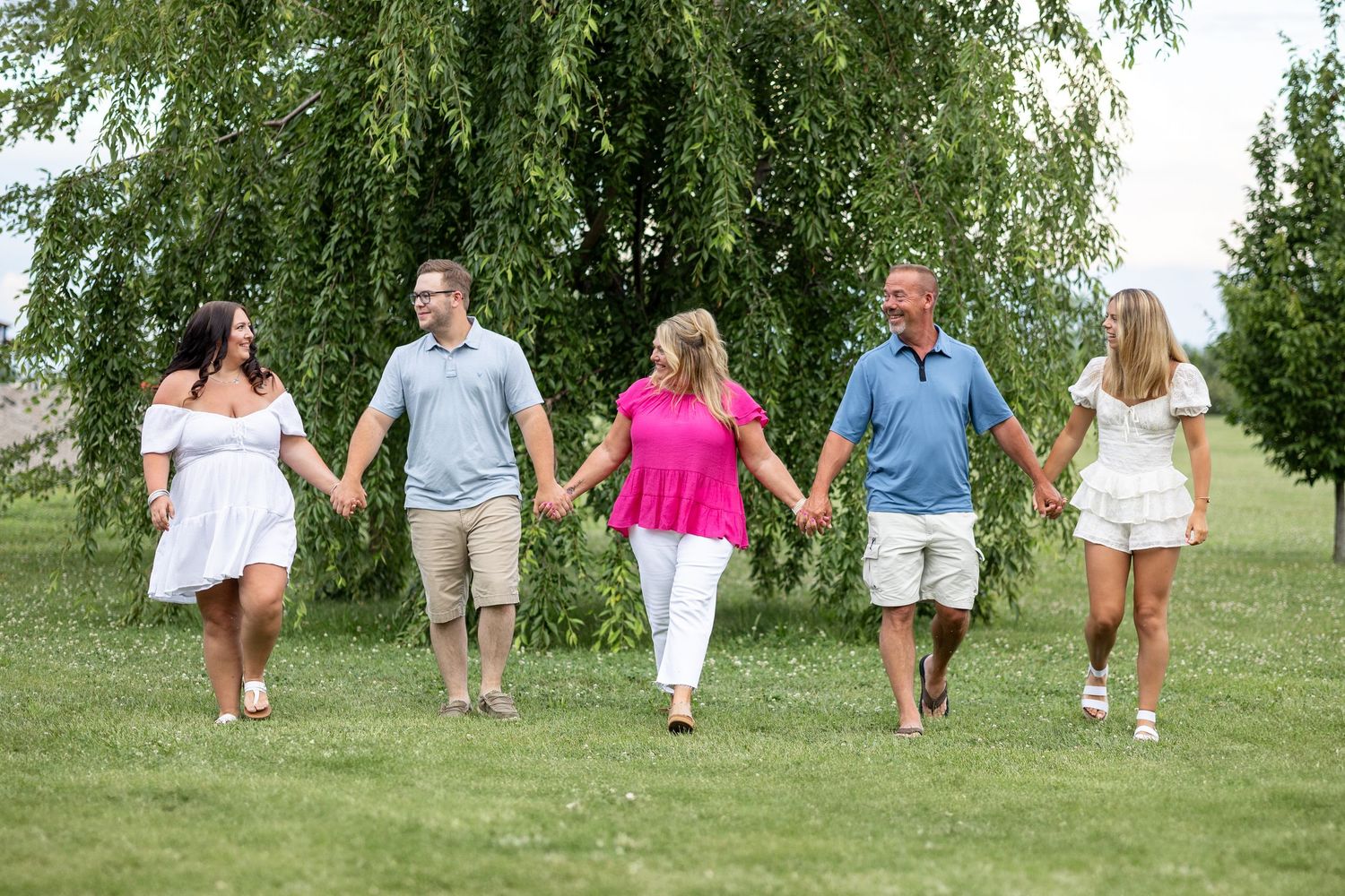 Springfield, IL photographer captures a family holding hands walking together at Centennial Park in Central IL