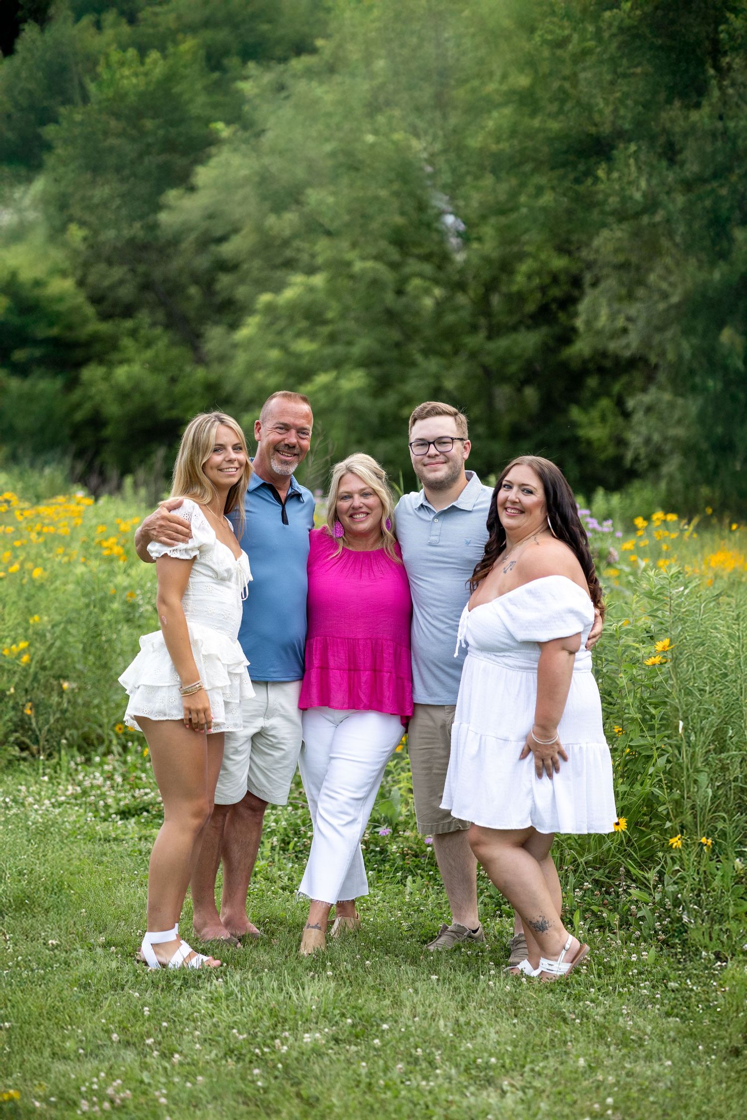 Springfield Il photographer captures a family together in front of wildflowers during a photo session at Centennial Park in Central IL