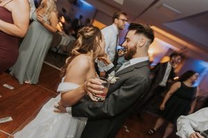 Dance floor celebration with guests dancing at wedding reception party.