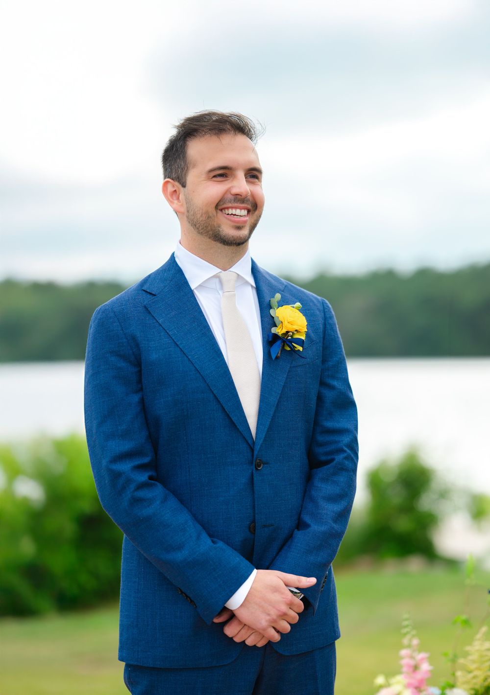 A groom smiles as his bride walks down the aisle at the Saphire Event Group's Lakehouse in Halifax, MA.