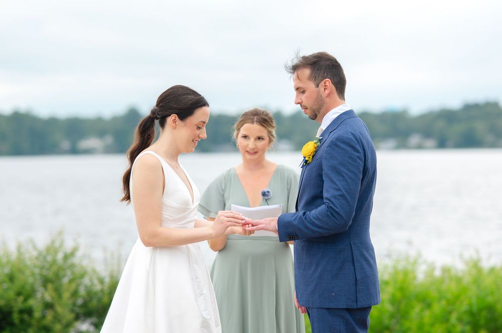 A couple shares a romantic moment by the waterfront during their elegant lakeside wedding celebration.