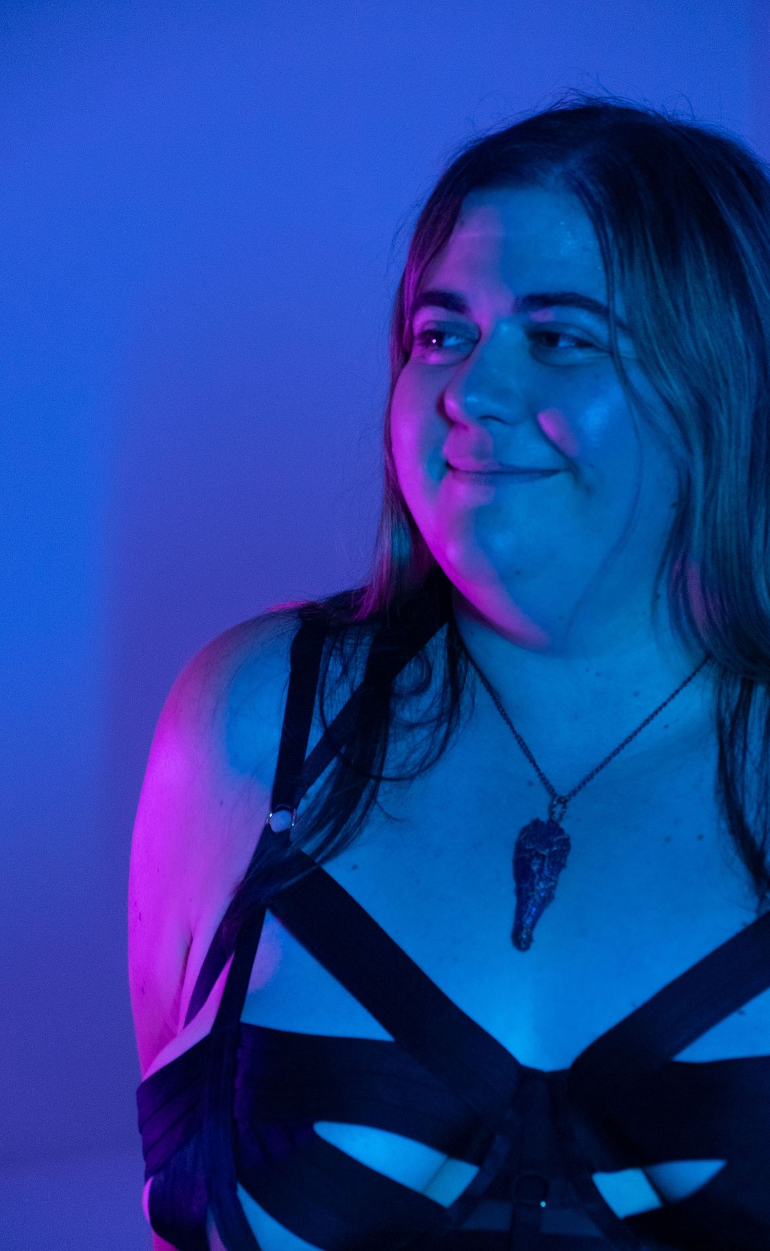 Portrait series lit with dramatic blue and pink lighting shows closeup expressions against dark background.