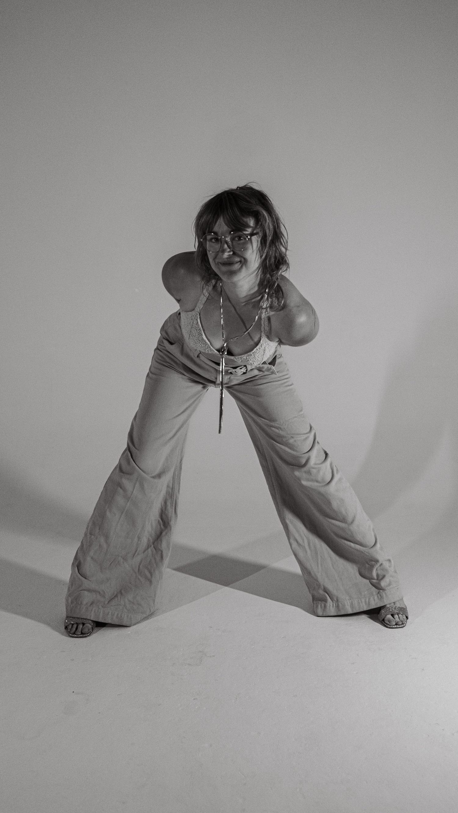 Black and white artistic photo series showing legs in wide stance positions against white background creating dynamic shapes.