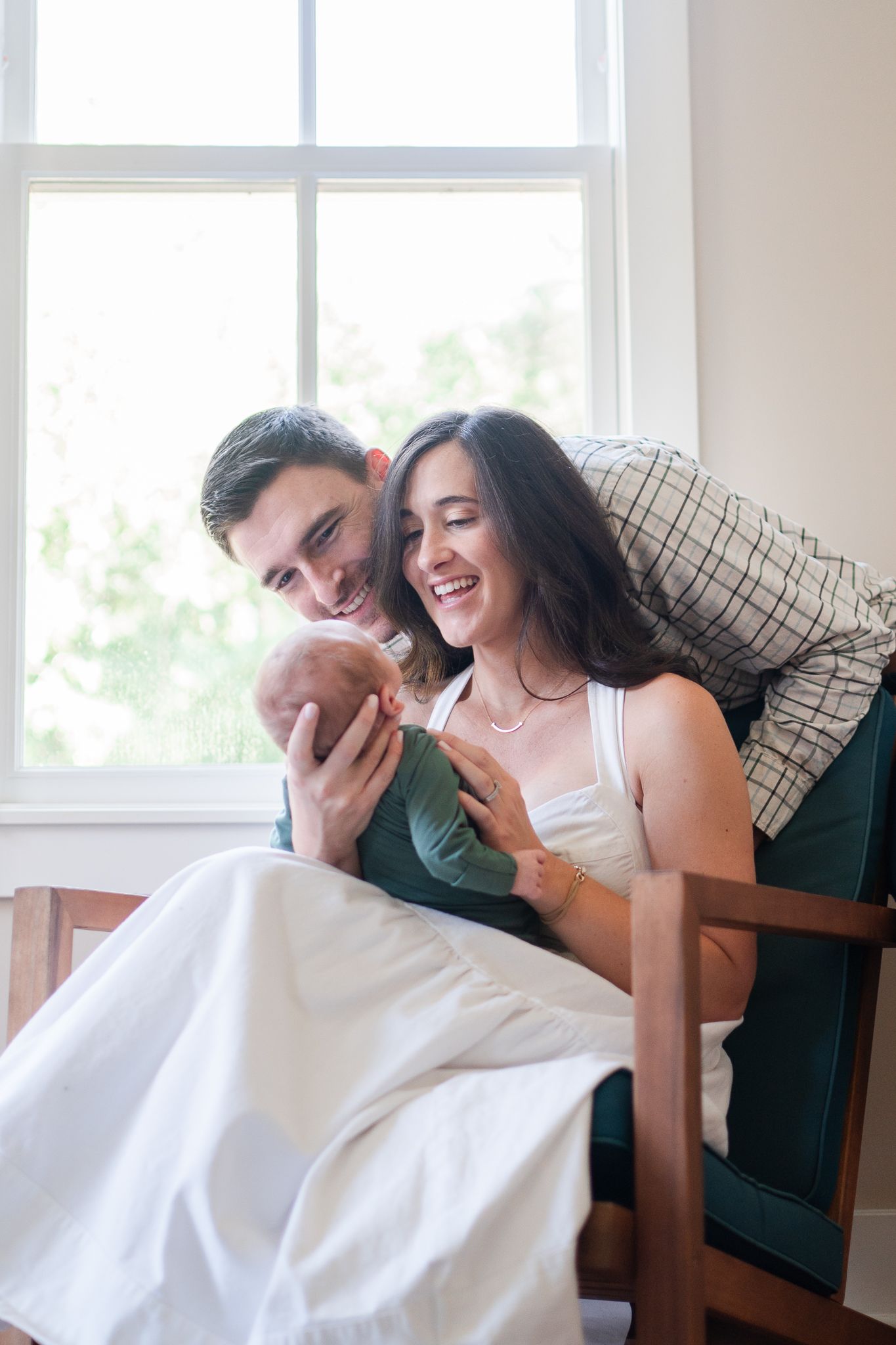 Proud parents smile at their newborn in their Winston-Salem newborn photos.
