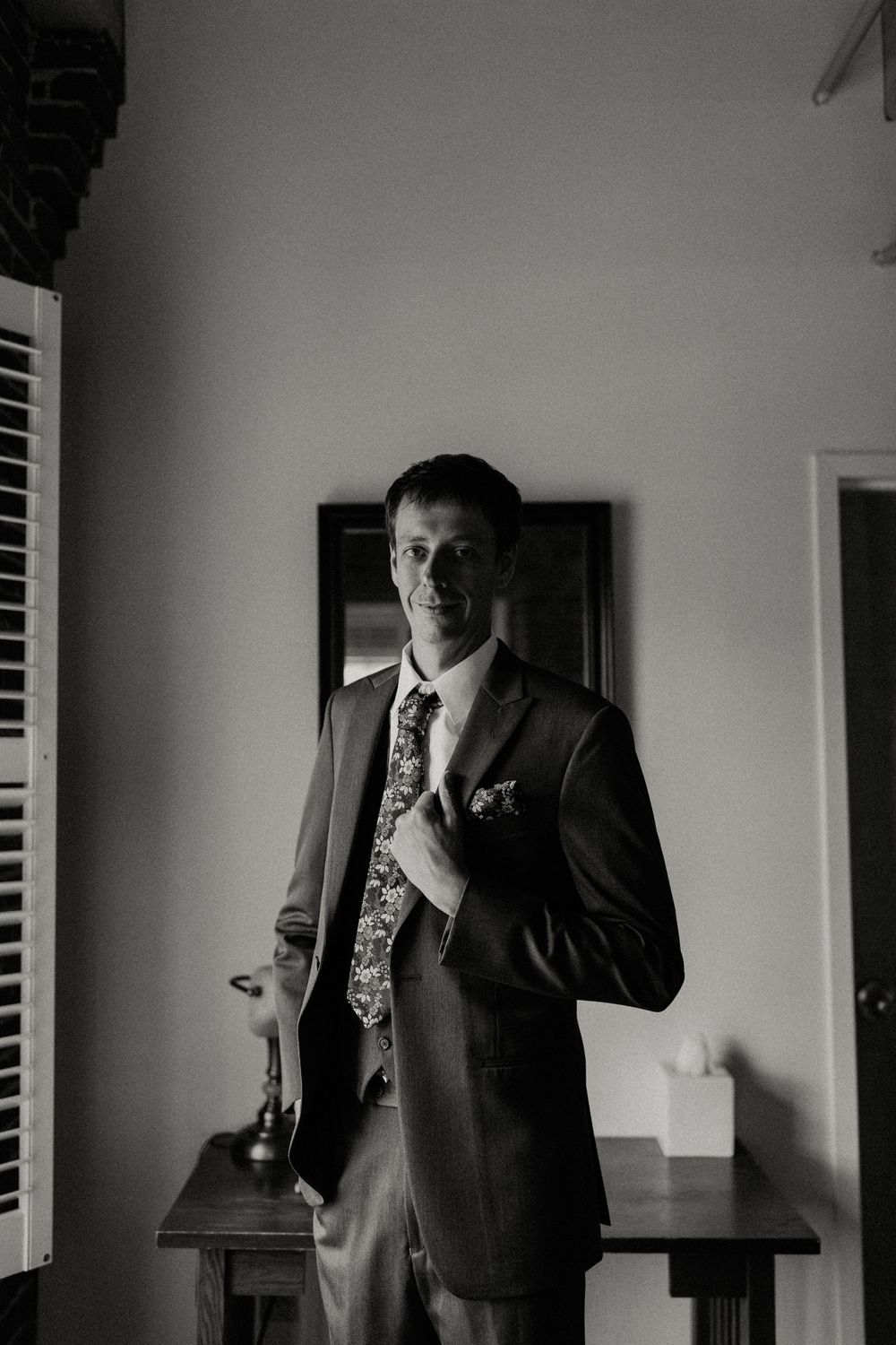 Black and white image of formal suit and tie silhouetted against light interior.
