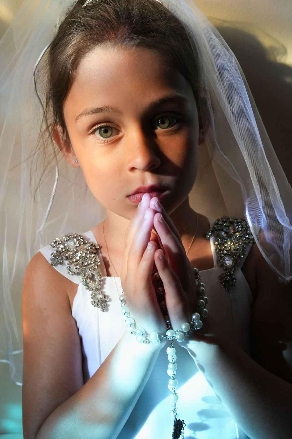 Bridal portrait series showing prayer-like poses with veil and crystal details.