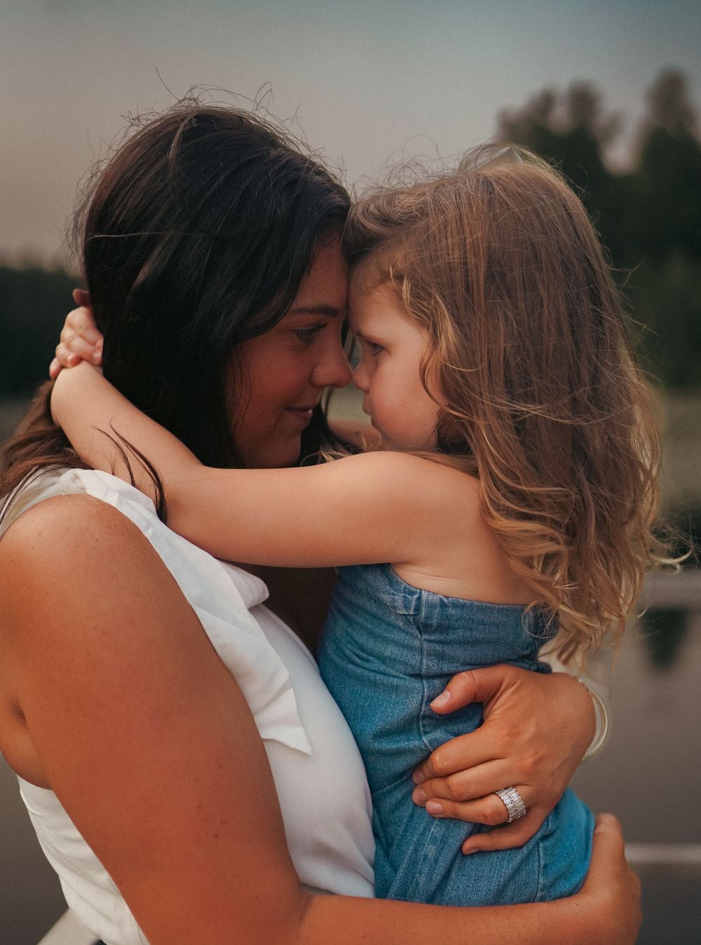Mother and child sharing an intimate embrace at sunset.