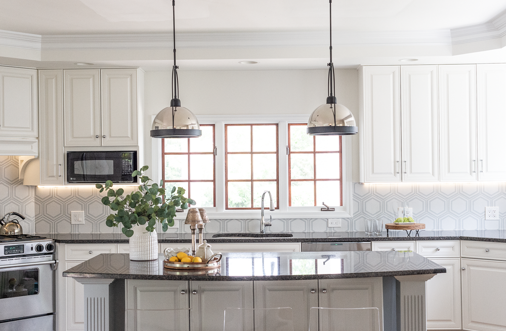 white kitchen with 2 pendants over island geometric backsplash