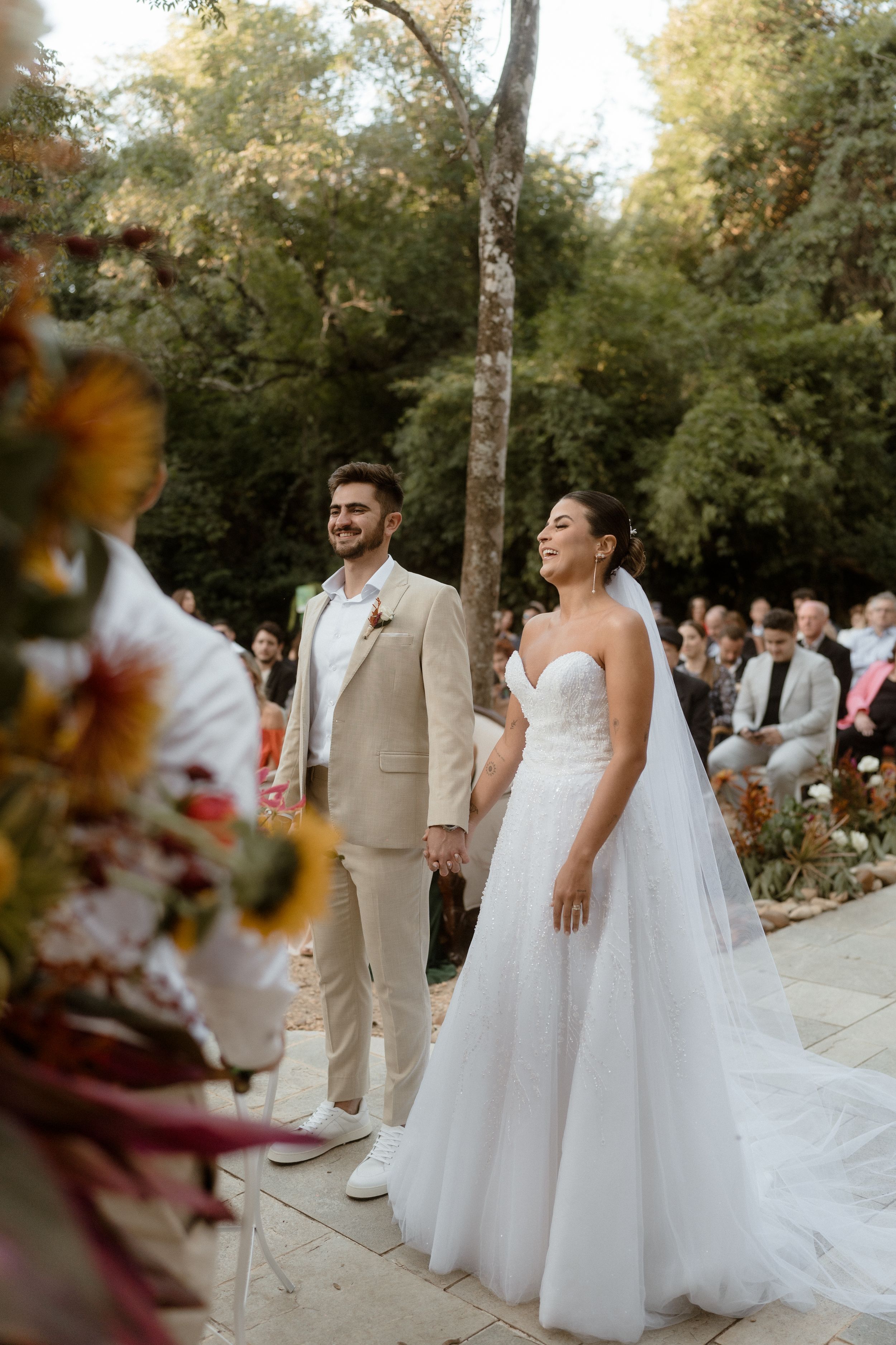 Couples in wedding attire stand together during an outdoor autumn ceremony.