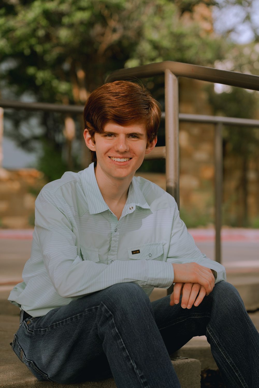 Casual portrait on concrete steps with someone wearing a light blue shirt.