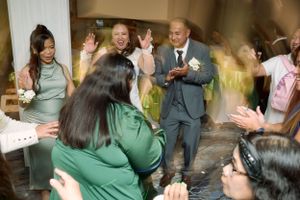 Wedding guests cheer and wave as the newlywed couple exits through a crowd at their celebration at Fairfield Inn & Suites Lodi, California.