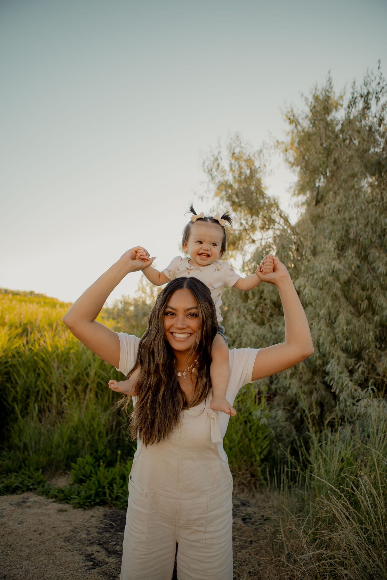 Joyful moment captured outdoors with sunlit trees in the background.