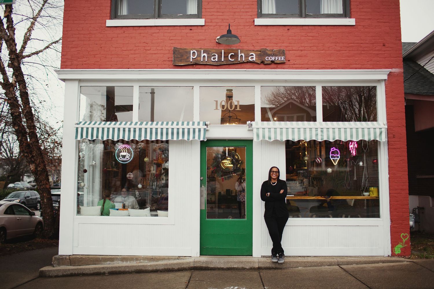 picture of a girl standing in front of phalcha coffee shop in louisville wearing black suit