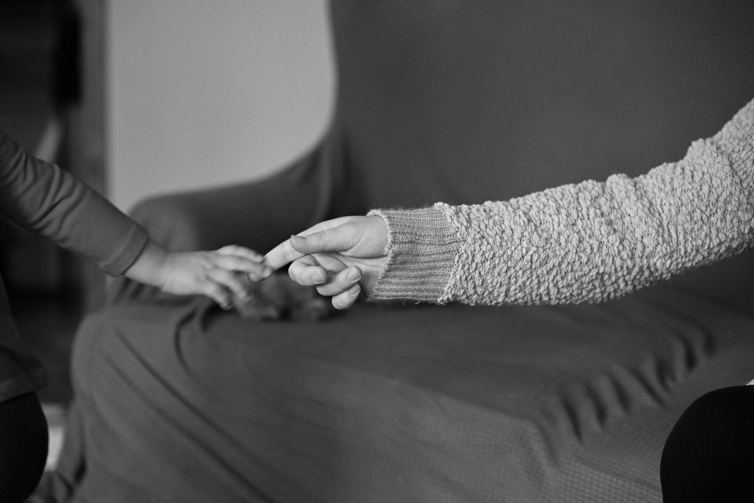 A black and white photograph of Emma's hand letting go of Amber's hand