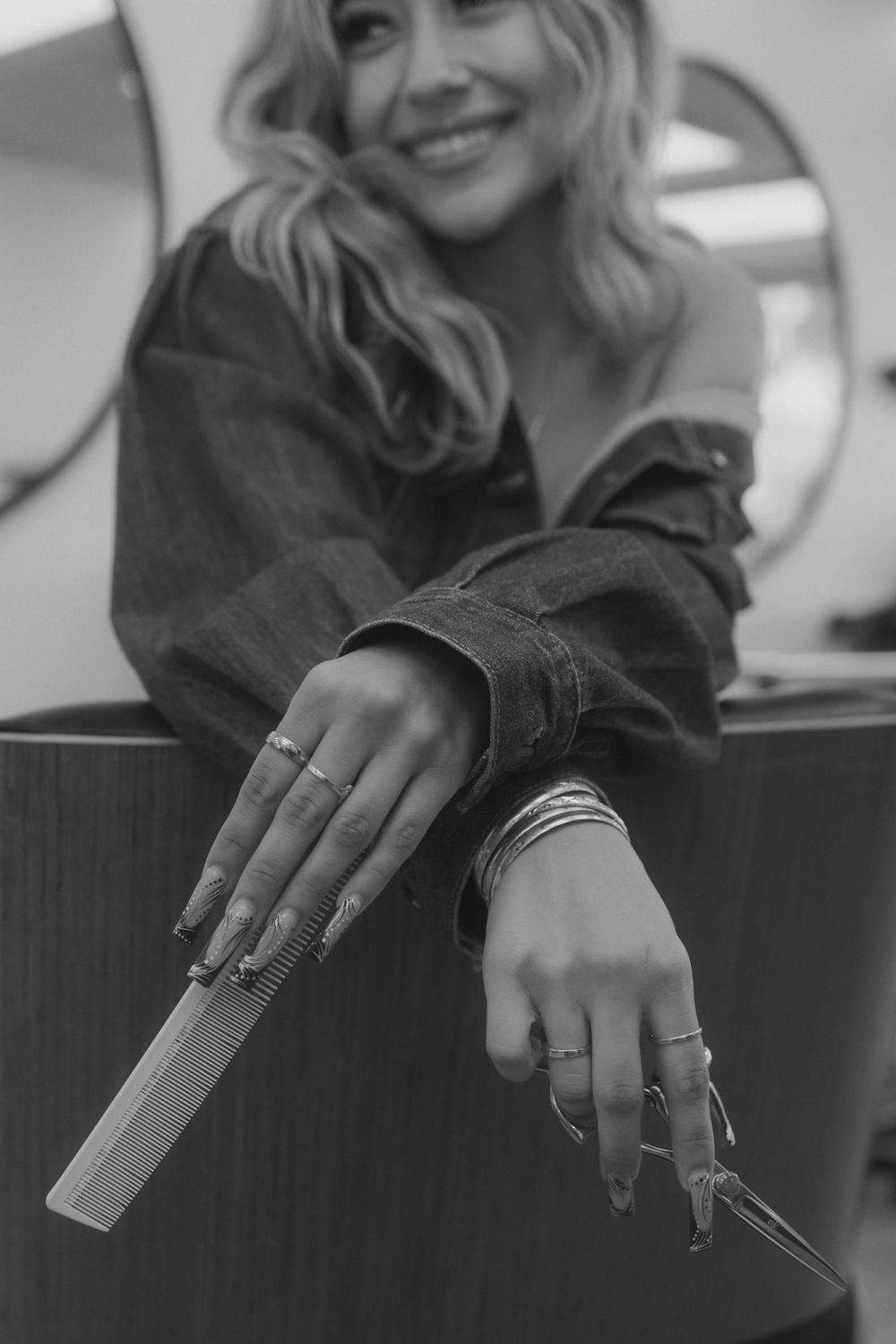 Close-up of hands holding hairstyling tools in a professional salon setting.
