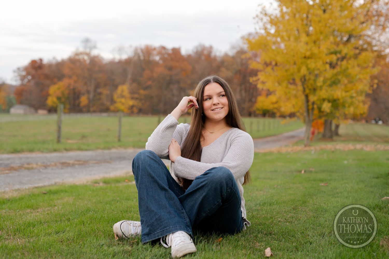 Casual outdoor portrait with autumn colors and trees in background.