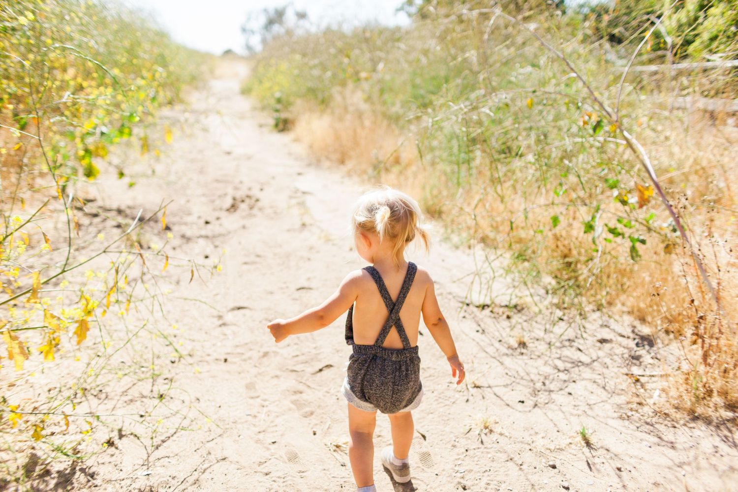 toddler wearing a romper in nature