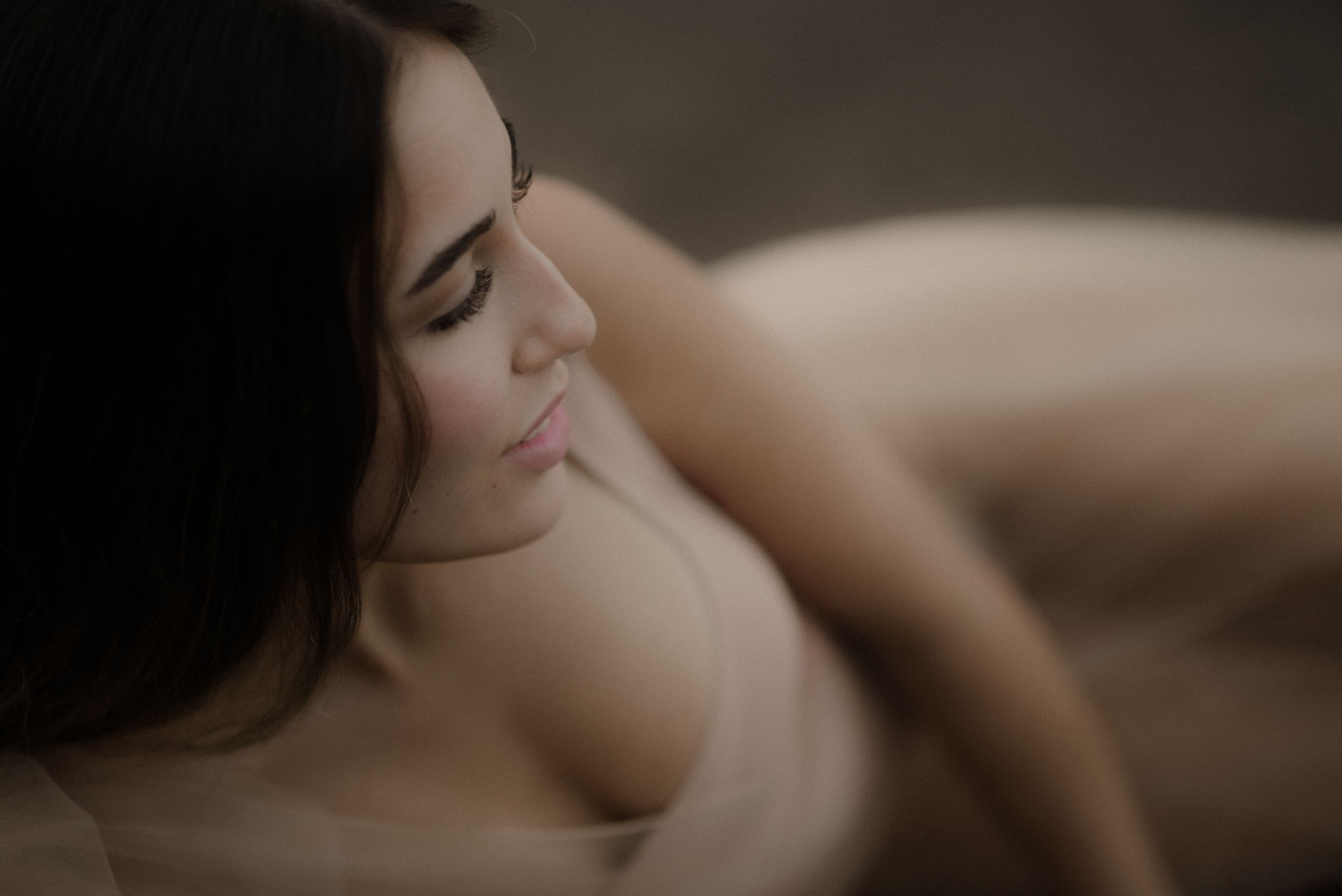 Intimate boudoir portrait with soft lighting and natural shadows.