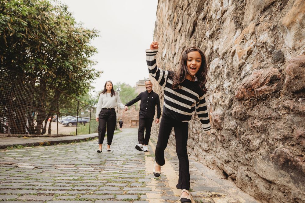 People walking along a rocky cliff path holding wine glasses during an outdoor wine tasting experience.