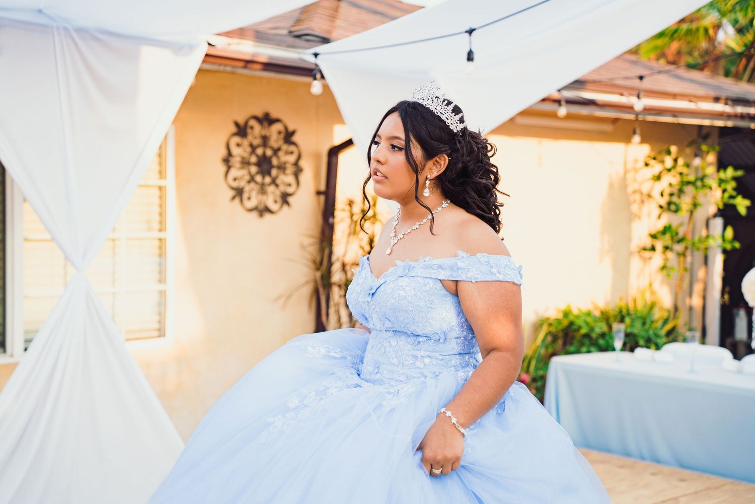 A series of photos showing someone in a light blue off-shoulder gown posing in an outdoor setting.