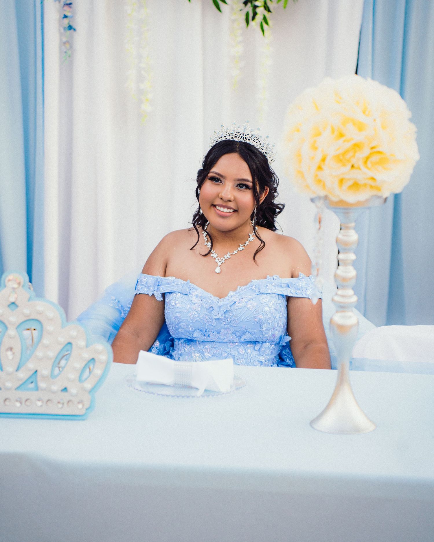 A wedding reception table decorated in soft blue and white with floral arrangements and elegant place settings.