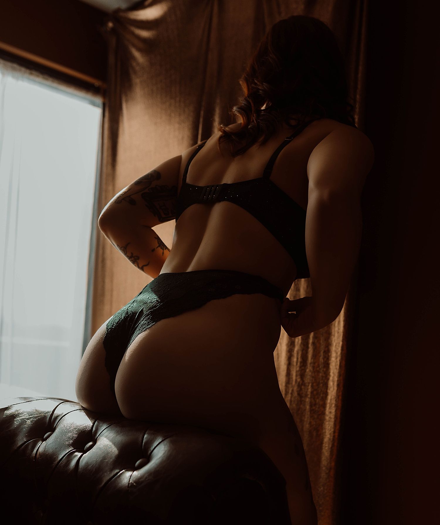 woman in lingerie leans over couch for 40th birthday gift