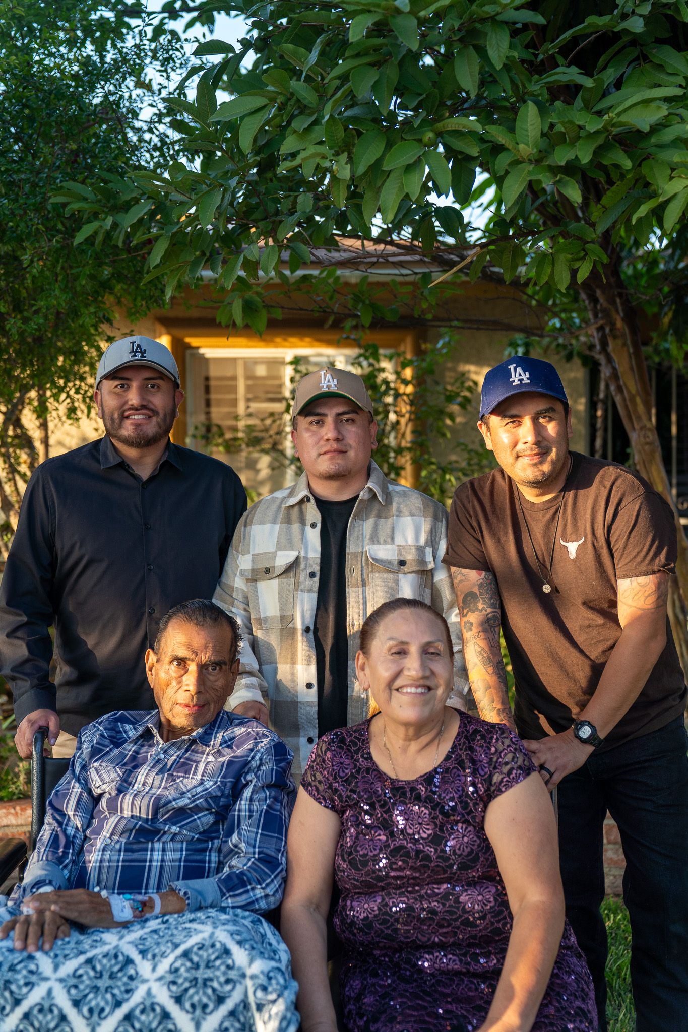 Family members gathered on a patio with lush greenery and trees creating a natural backdrop.