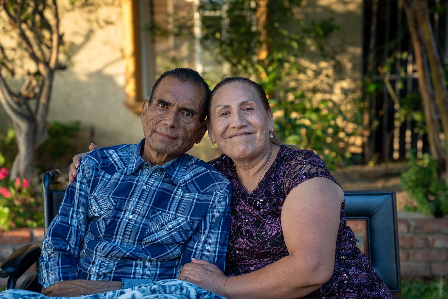 A tender outdoor moment between two people in plaid and purple embracing during golden hour.