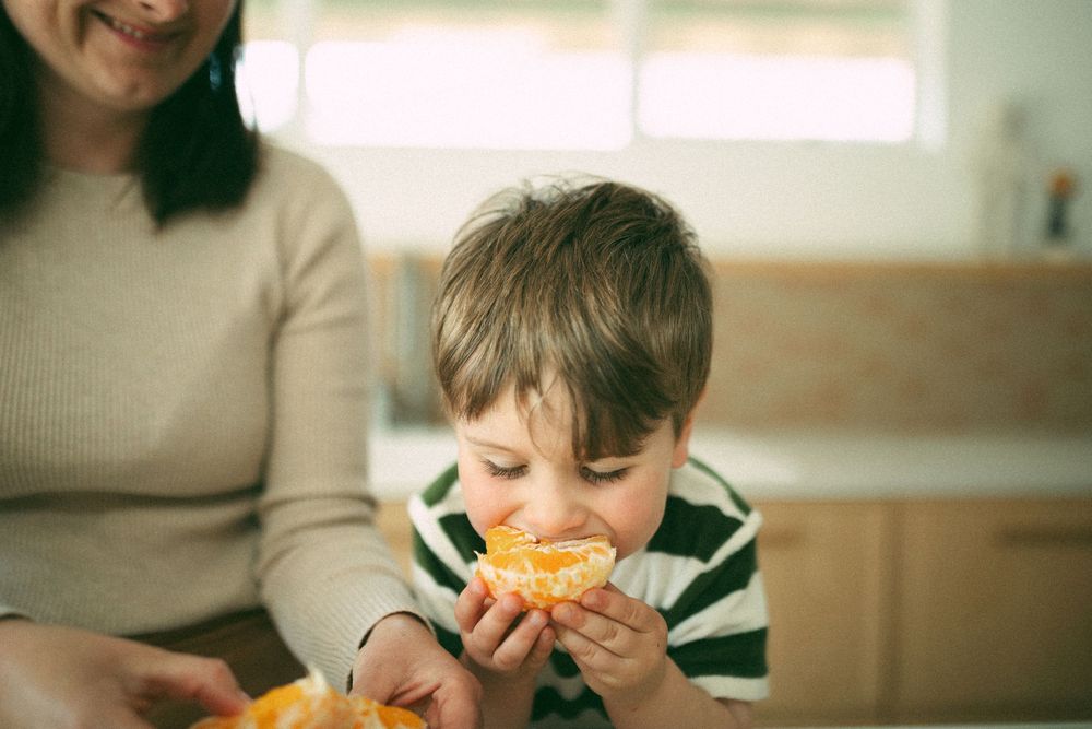 A sequence of photos showing someone eating an orange slice with various playful expressions.