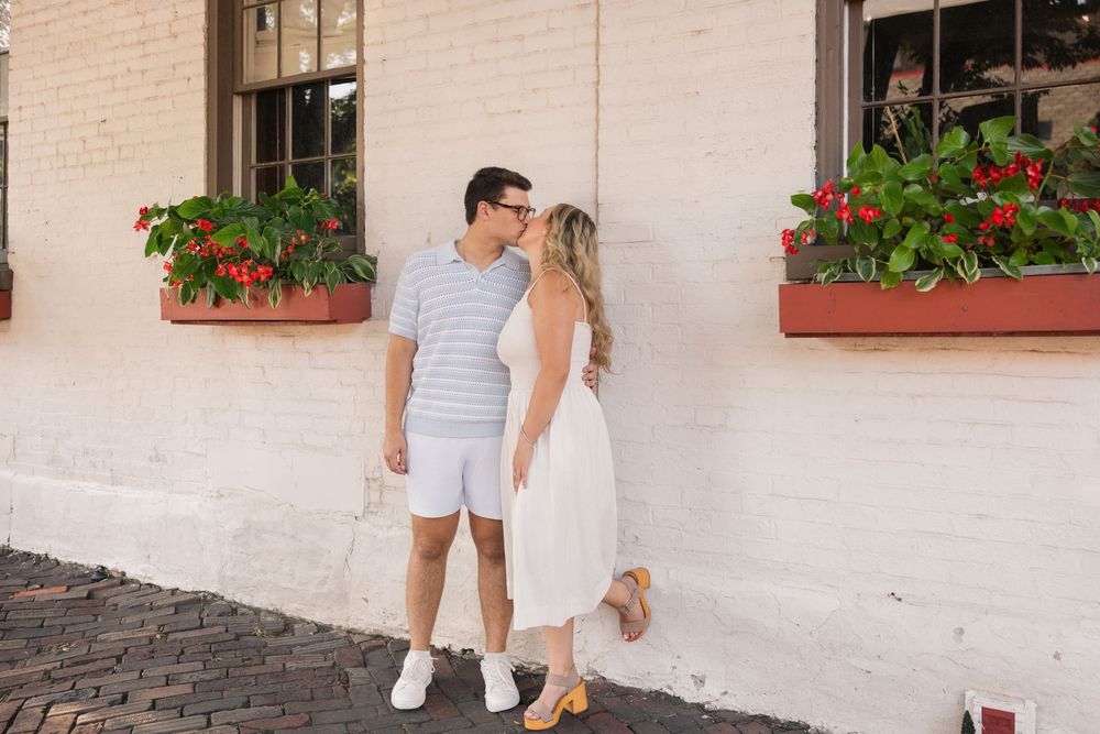 Romantic couple sharing a tender moment against a brick wall with flower boxes in an outdoor setting. German Village Columbus Ohio