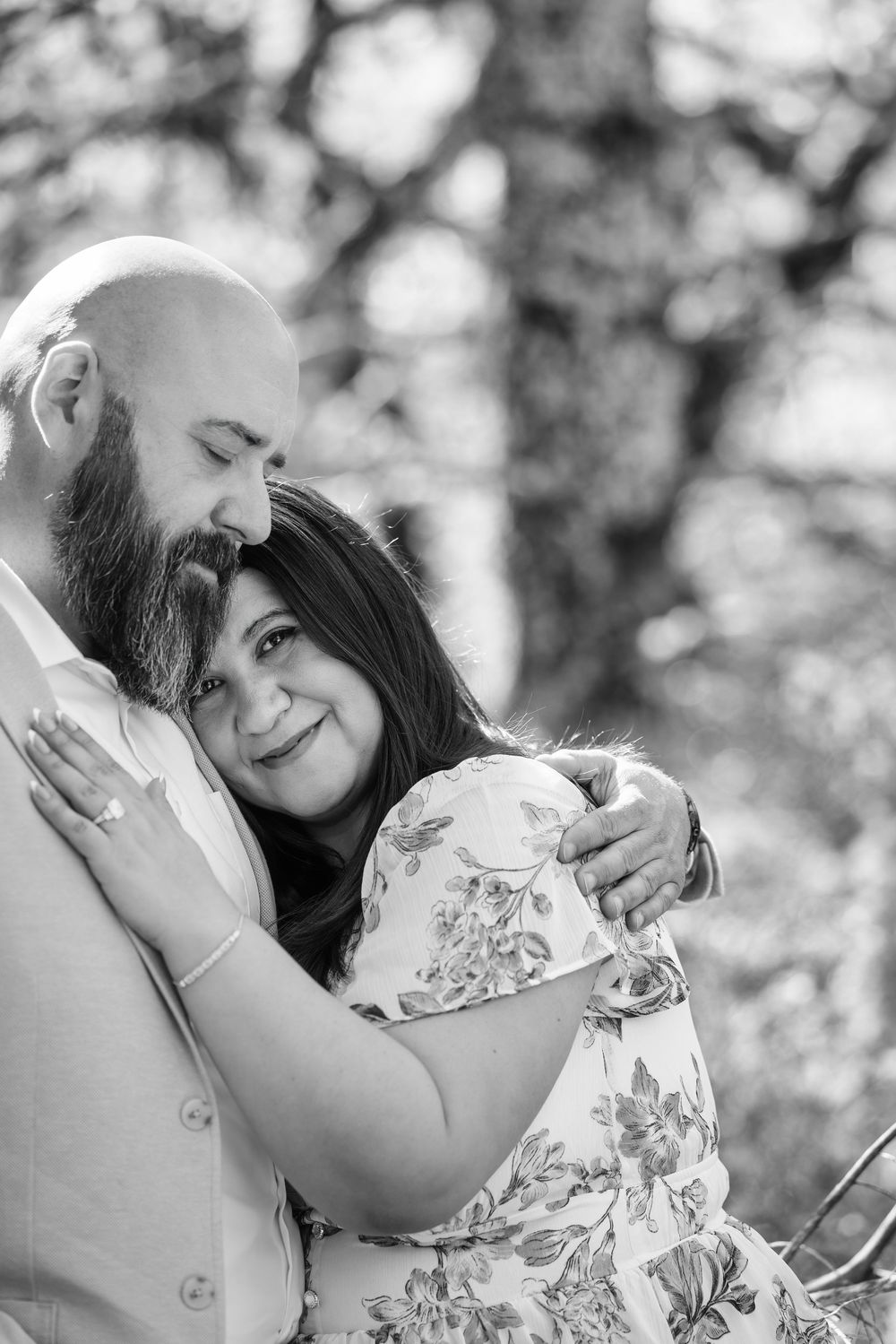 Black and white engagement photos showing tender embraces between a couple in a garden setting.