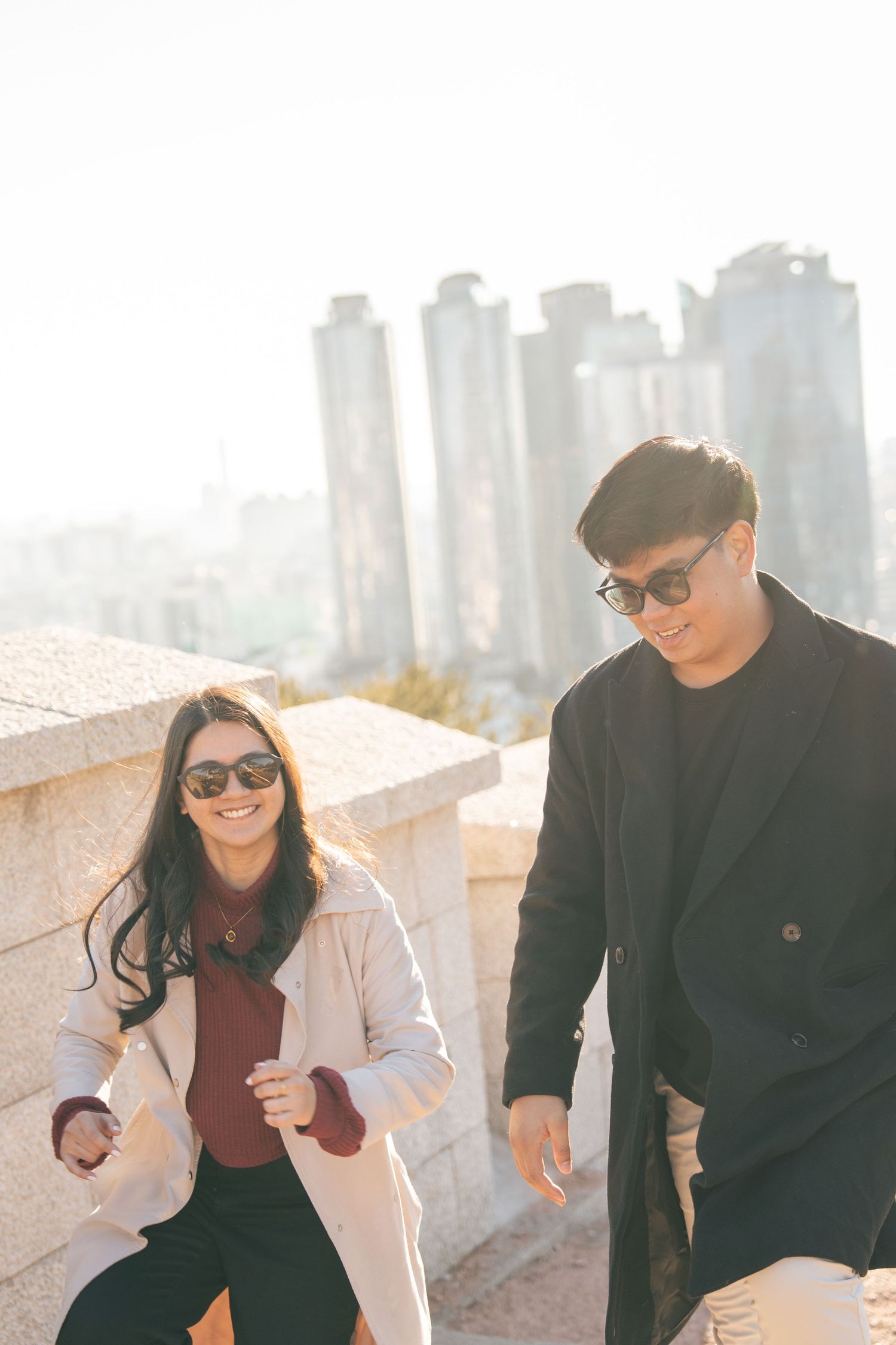 A couple in sunglasses and dark outfits share playful moments together in a series of candid outdoor photos.