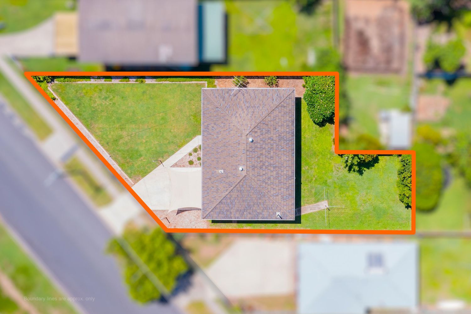 Top-down aerial view of a corner residential block with orange boundary outline highlighting the land size.