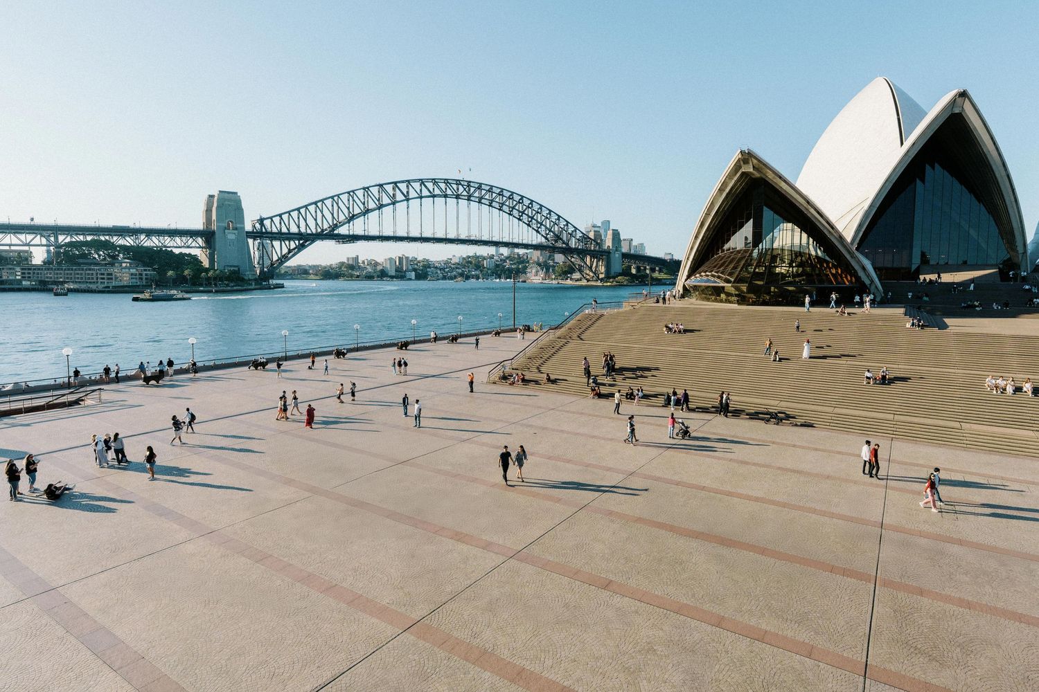 Panoramic collage of Sydney Opera House and Harbour Bridge from multiple angles with visitors on the forecourt.